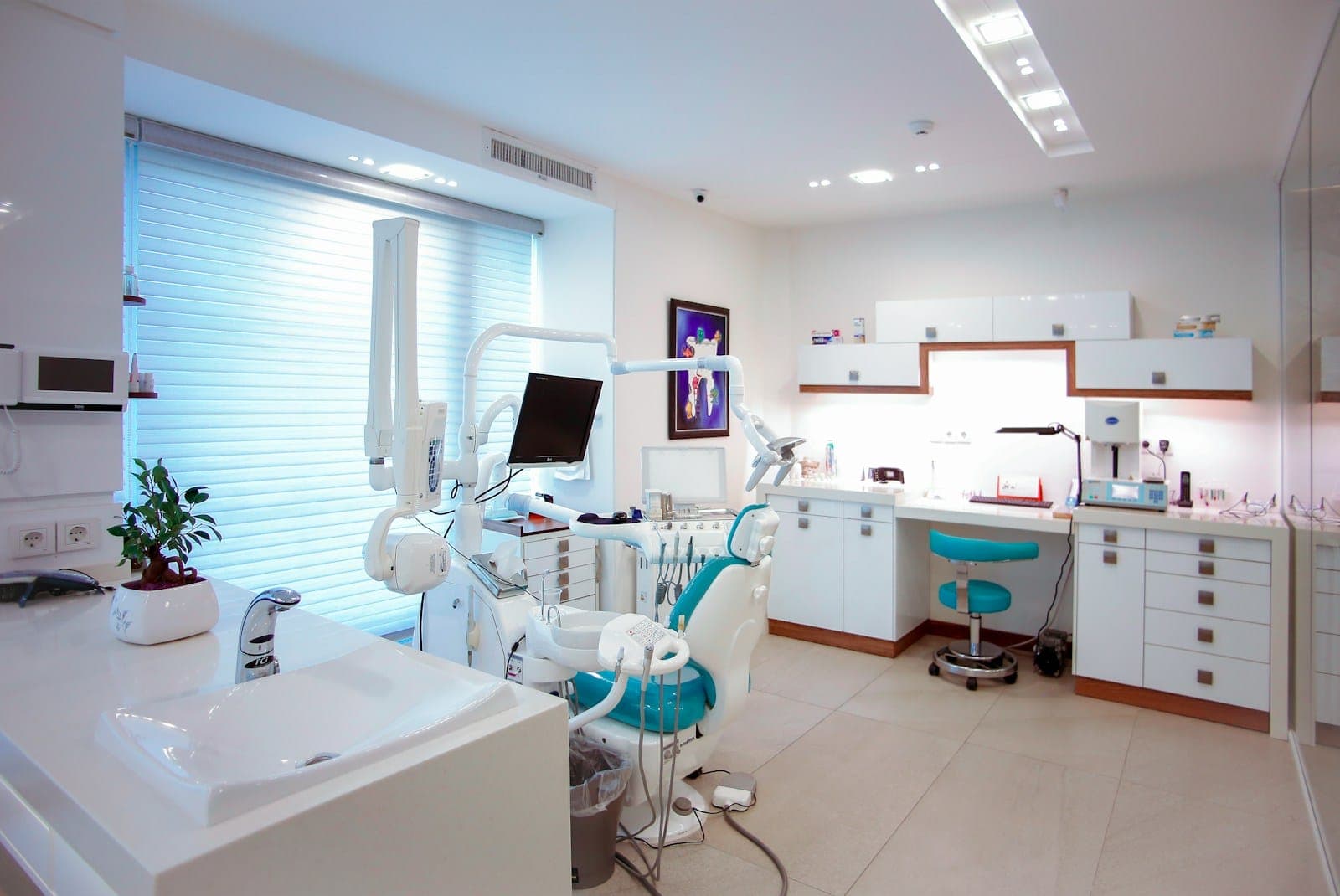 A bright, modern dental treatment room with a patient chair and equipment