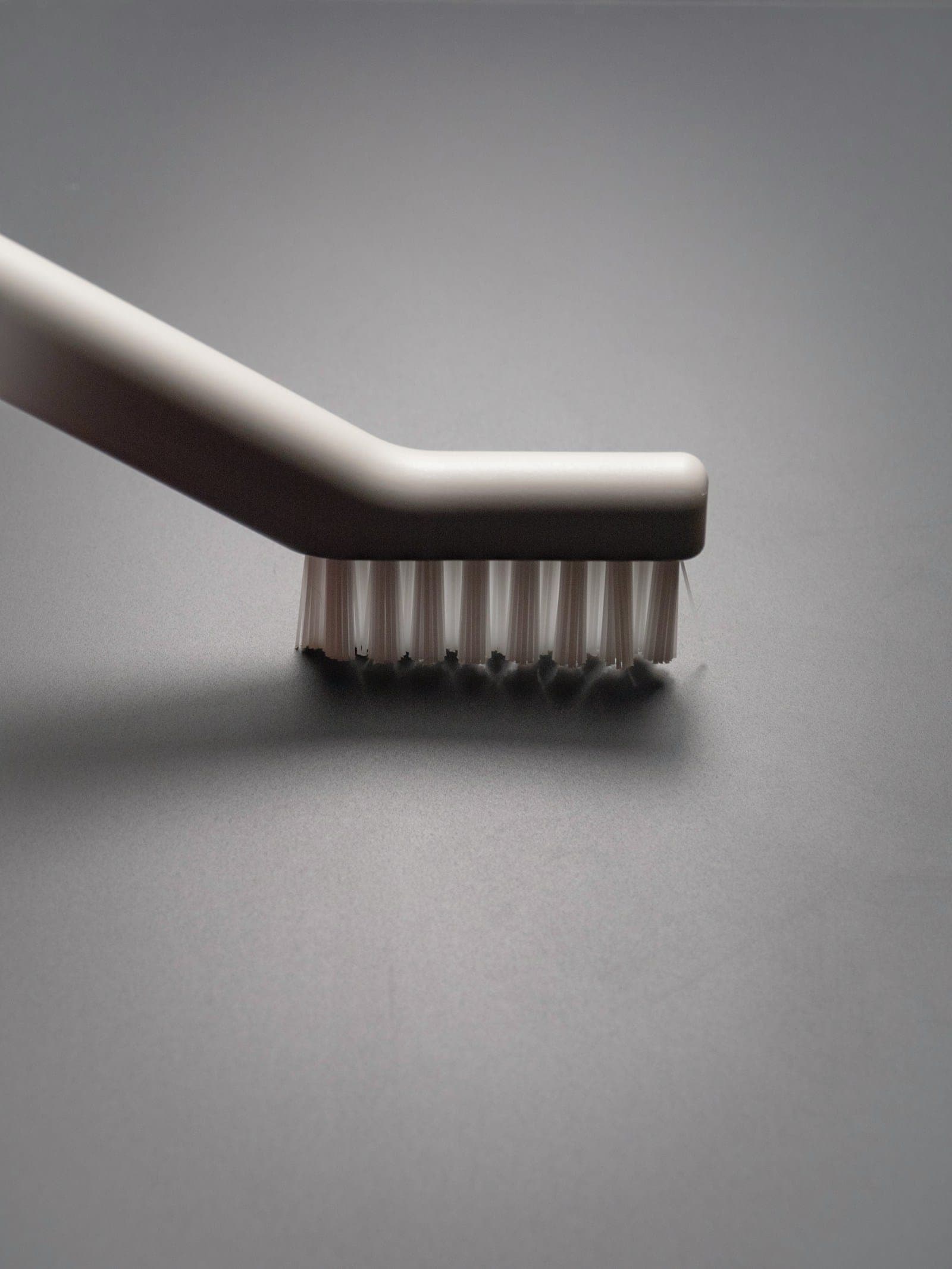 Close-up of a soft-bristled toothbrush resting on a gray surface