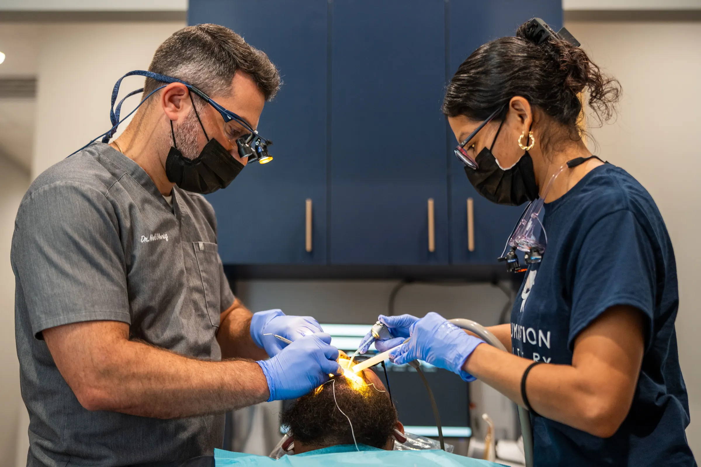 Dr. Noah Honig and Staff 3 treating a patient with a curing light at Illumination Dentistry